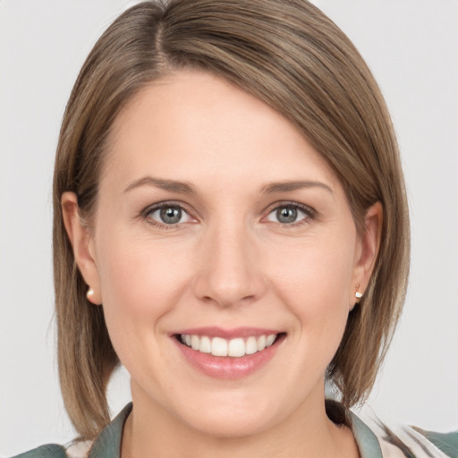 Joyful white young-adult female with medium  brown hair and grey eyes