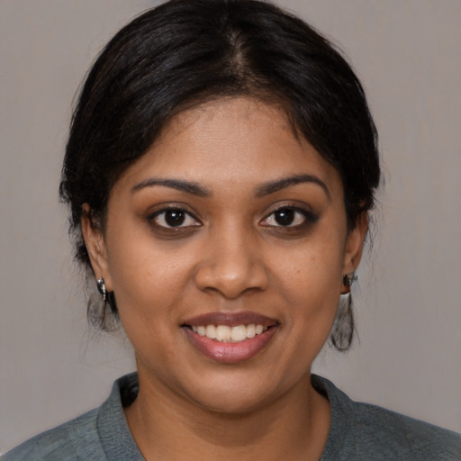 Joyful black young-adult female with medium  black hair and brown eyes