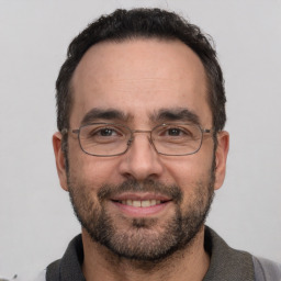 Joyful white adult male with short  black hair and brown eyes
