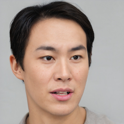 Joyful asian young-adult male with short  black hair and brown eyes