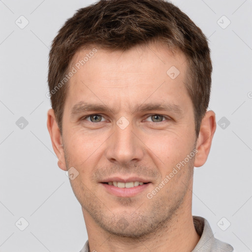 Joyful white young-adult male with short  brown hair and grey eyes