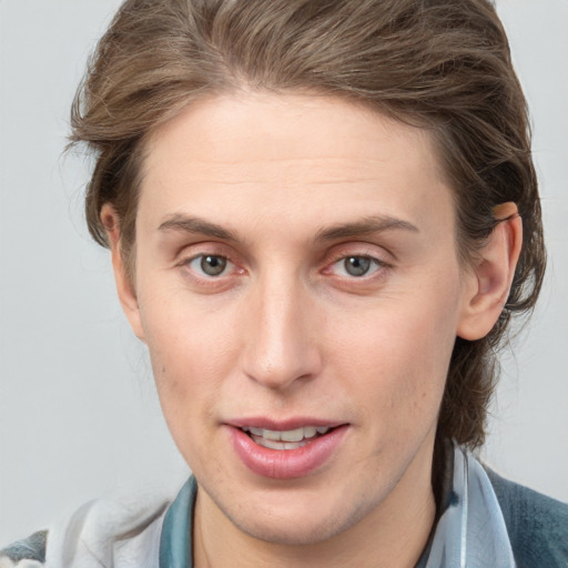 Joyful white young-adult male with medium  brown hair and grey eyes