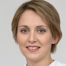 Joyful white young-adult female with medium  brown hair and green eyes