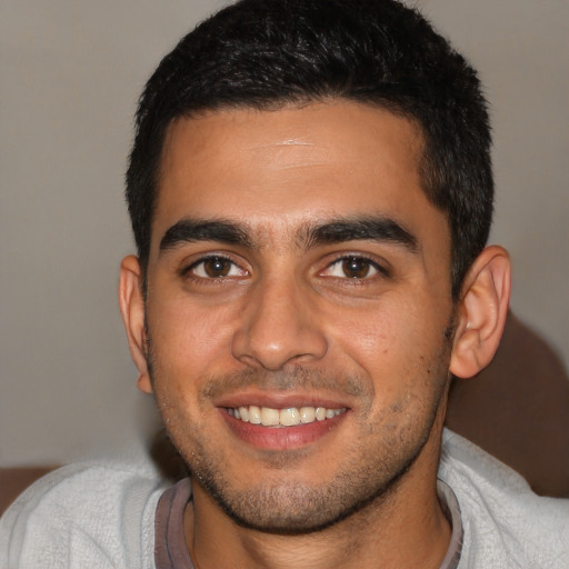 Joyful latino young-adult male with short  brown hair and brown eyes