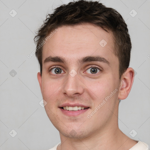 Joyful white young-adult male with short  brown hair and grey eyes