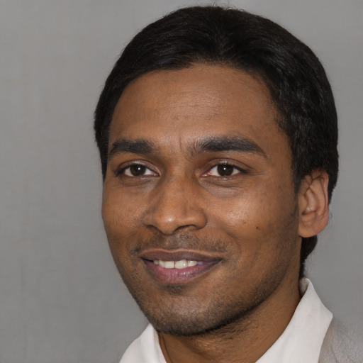Joyful black young-adult male with short  black hair and brown eyes