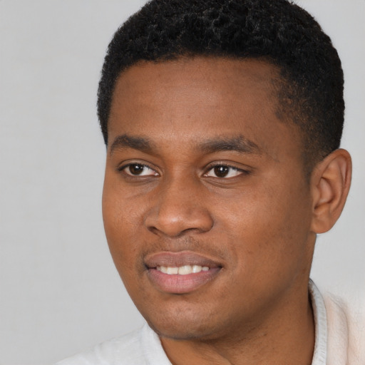 Joyful black young-adult male with short  black hair and brown eyes