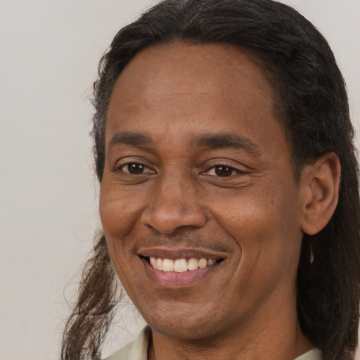 Joyful latino adult male with long  brown hair and brown eyes