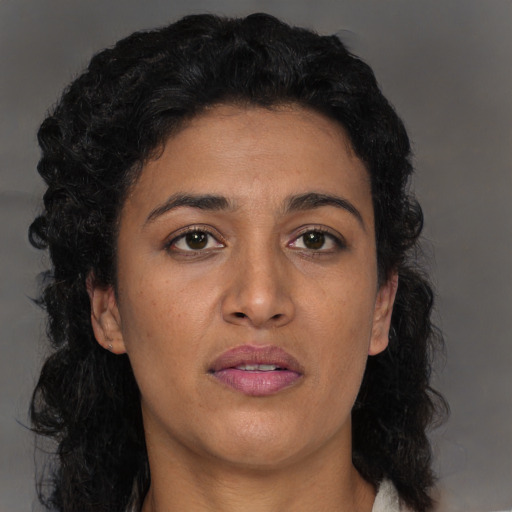 Joyful black young-adult female with long  black hair and brown eyes