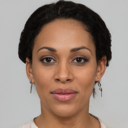 Joyful black young-adult female with short  brown hair and brown eyes