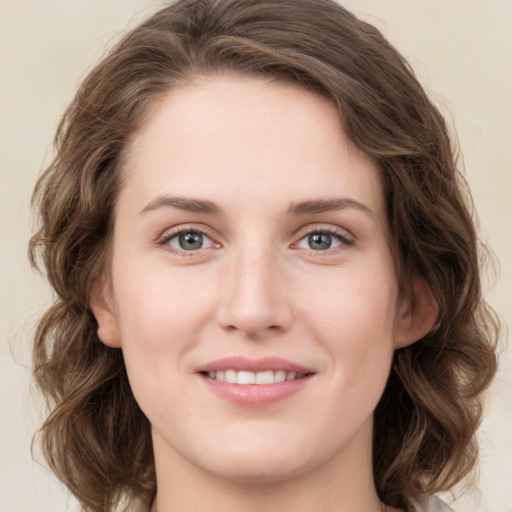 Joyful white young-adult female with medium  brown hair and green eyes