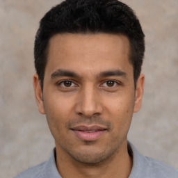 Joyful latino young-adult male with short  black hair and brown eyes