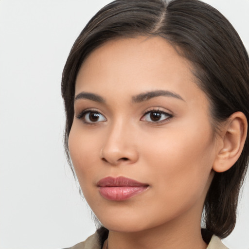 Joyful latino young-adult female with long  brown hair and brown eyes