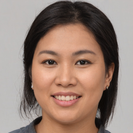 Joyful asian young-adult female with medium  brown hair and brown eyes