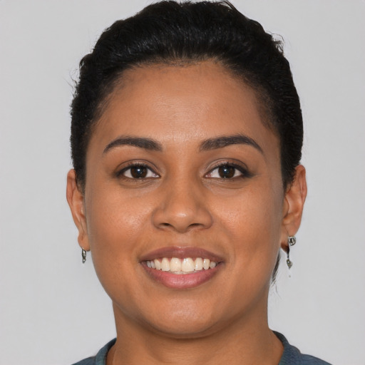 Joyful latino young-adult female with short  black hair and brown eyes