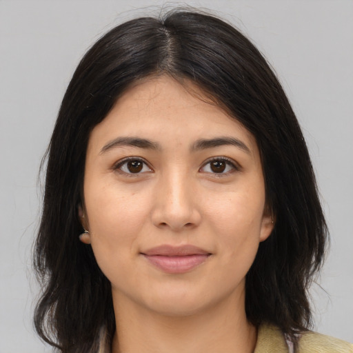 Joyful latino young-adult female with medium  brown hair and brown eyes