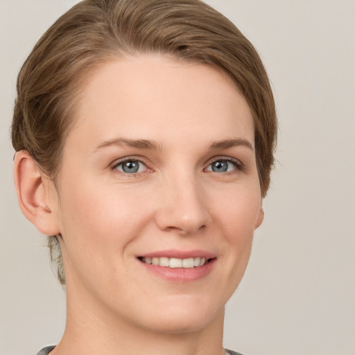 Joyful white young-adult female with short  brown hair and grey eyes