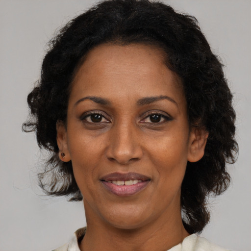 Joyful black adult female with medium  brown hair and brown eyes