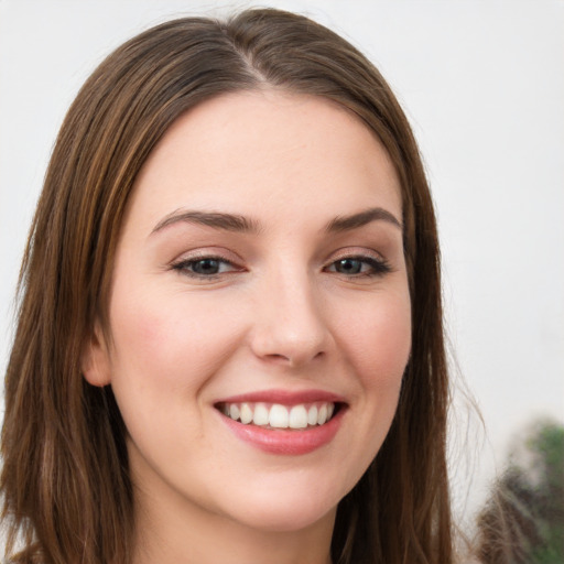 Joyful white young-adult female with long  brown hair and green eyes