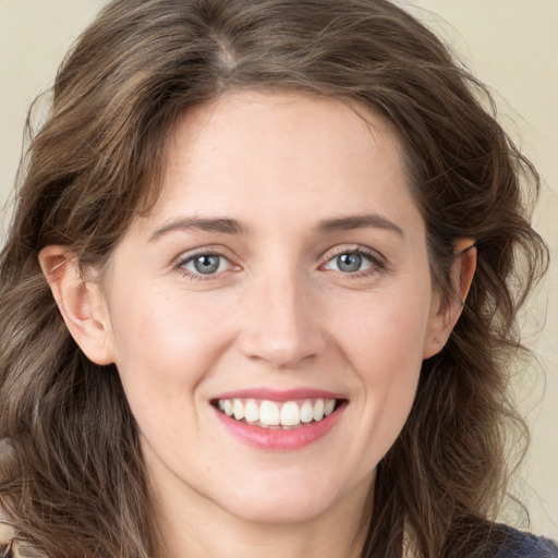 Joyful white young-adult female with long  brown hair and blue eyes