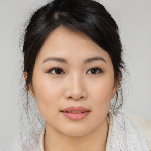 Joyful asian young-adult female with medium  brown hair and brown eyes