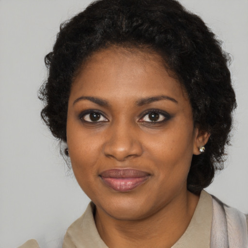 Joyful black young-adult female with long  black hair and brown eyes