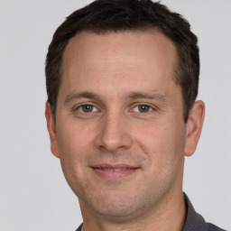 Joyful white adult male with short  brown hair and grey eyes