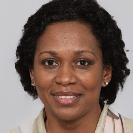 Joyful black adult female with short  black hair and brown eyes