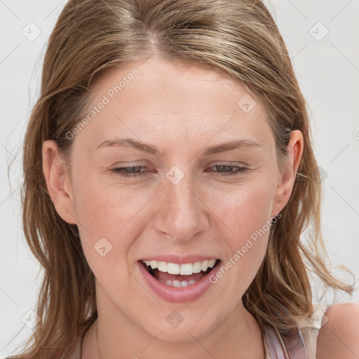 Joyful white young-adult female with long  brown hair and blue eyes