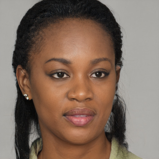 Joyful black young-adult female with long  brown hair and brown eyes