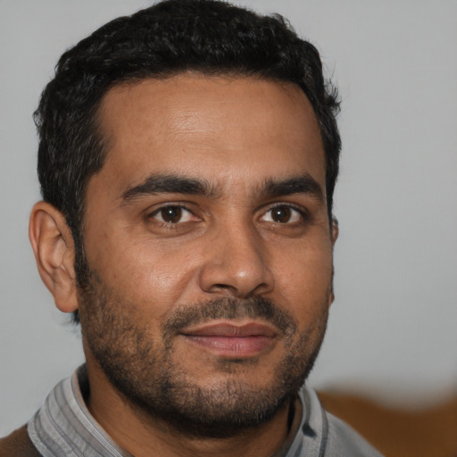 Joyful latino young-adult male with short  black hair and brown eyes