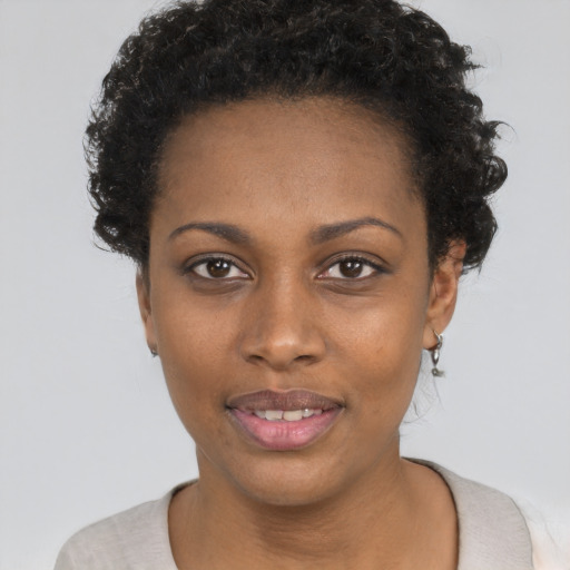 Joyful black young-adult female with short  black hair and brown eyes