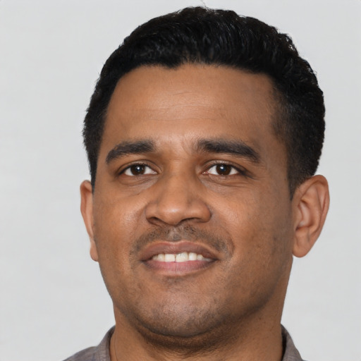 Joyful latino young-adult male with short  black hair and brown eyes