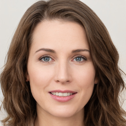 Joyful white young-adult female with long  brown hair and green eyes