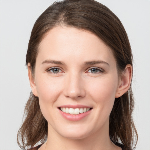 Joyful white young-adult female with medium  brown hair and grey eyes