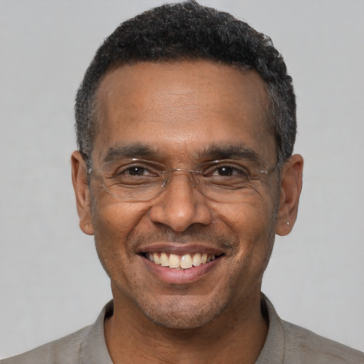 Joyful black adult male with short  black hair and brown eyes