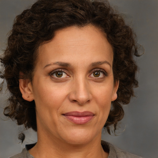 Joyful white adult female with medium  brown hair and green eyes