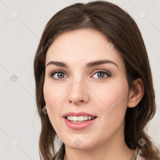 Joyful white young-adult female with long  brown hair and grey eyes