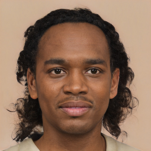 Joyful black young-adult male with medium  black hair and brown eyes