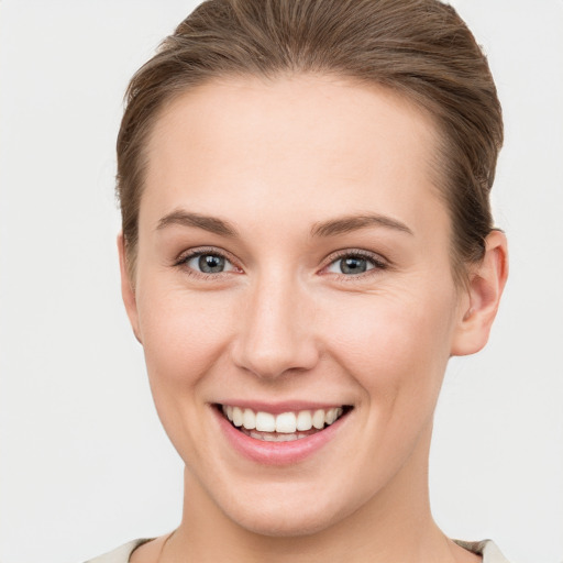 Joyful white young-adult female with short  brown hair and grey eyes