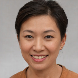 Joyful asian young-adult female with short  brown hair and brown eyes