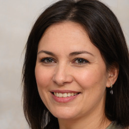 Joyful white adult female with medium  brown hair and brown eyes