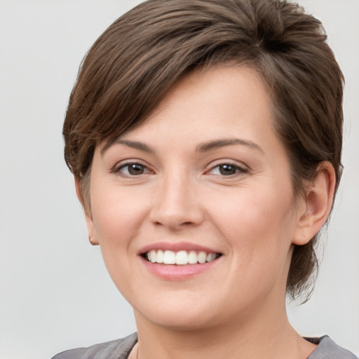 Joyful white young-adult female with medium  brown hair and grey eyes