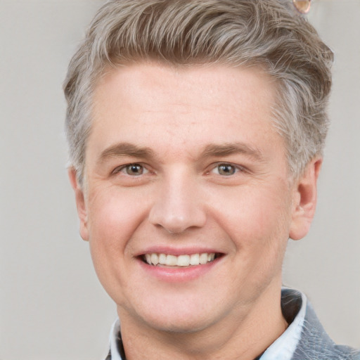 Joyful white adult male with short  brown hair and grey eyes