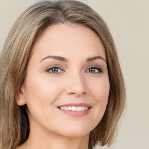 Joyful white young-adult female with medium  brown hair and green eyes