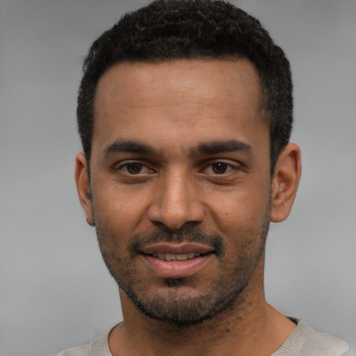 Joyful black young-adult male with short  black hair and brown eyes