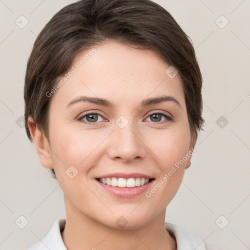 Joyful white young-adult female with short  brown hair and grey eyes