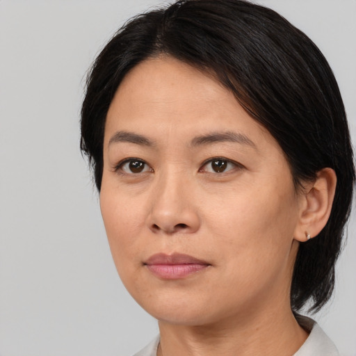 Joyful asian adult female with medium  brown hair and brown eyes