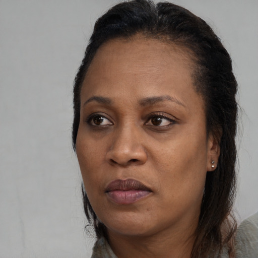 Joyful black adult female with long  brown hair and brown eyes