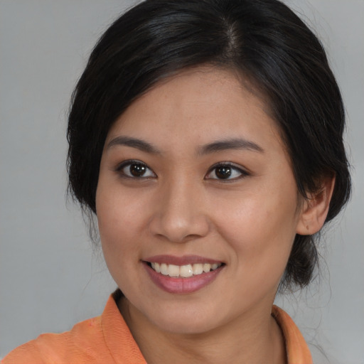 Joyful asian young-adult female with medium  brown hair and brown eyes